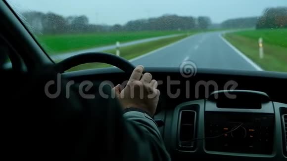 从里面看人在雨中行驶在寂寞的公路上视频的预览图