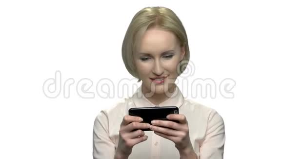 漂亮的金发女人用她的手机视频的预览图