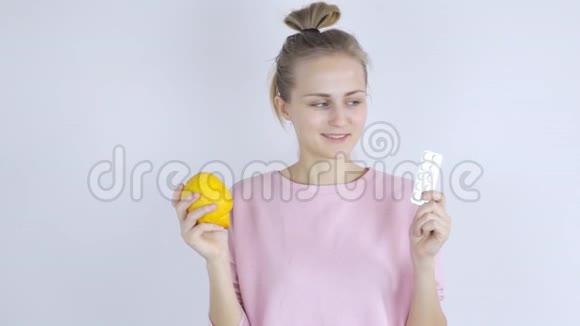 年轻女人在药片和柠檬之间选择视频的预览图