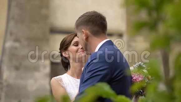 浪漫的婚礼气氛一对时髦的微笑的新婚夫妇在户外轻轻地摩擦鼻子背面视图视频的预览图