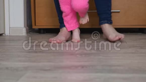 孩子和母亲的腿赤脚踩在地板上视频的预览图