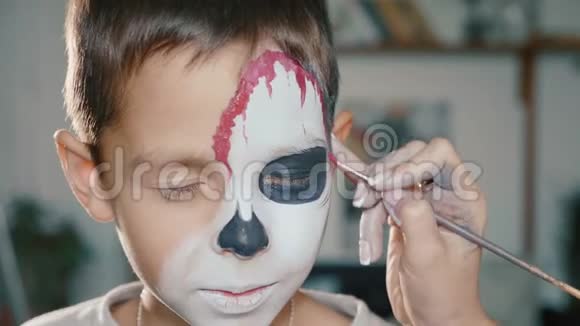 化妆师给男孩做万圣节化妆万圣节儿童脸艺术视频的预览图