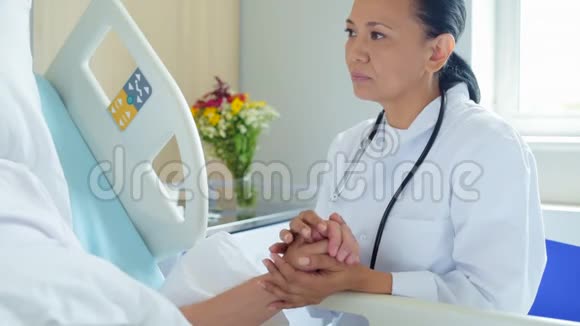 微笑着的女医生握着她住院病人的手视频的预览图