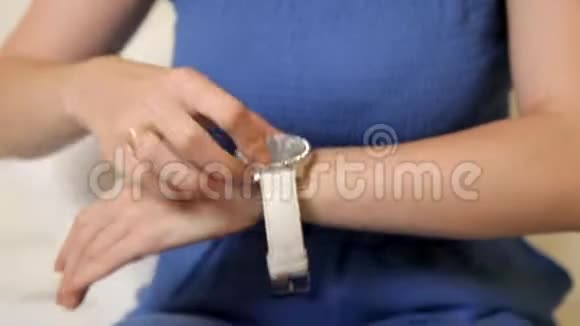 一个穿着蓝色西装的漂亮女孩正戴着白色手表视频的预览图