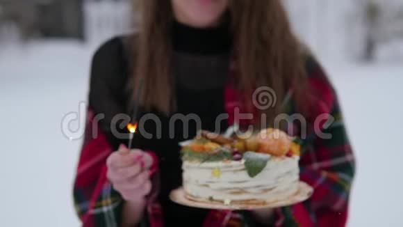 年轻女子在街上拿着圣诞蛋糕下雪了闪闪发光视频的预览图