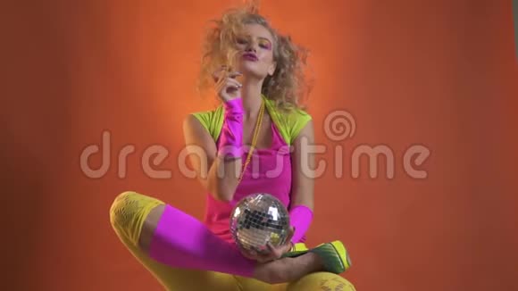 穿着80年代服装的金发女人玩弄她的头发视频的预览图