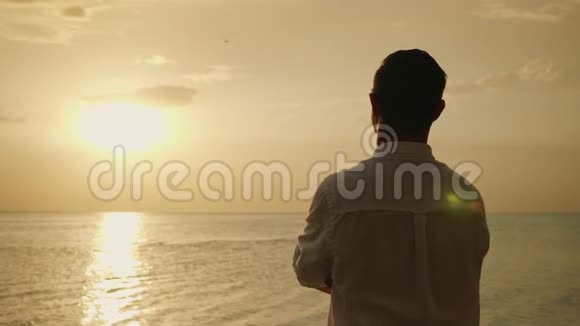 孤独的人期待着大海上的日落后景浪漫和海上度假4k慢动作视频视频的预览图
