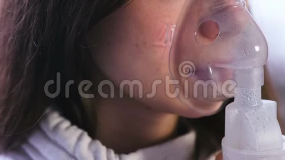 使用雾化器和吸入器进行治疗年轻女性通过吸入面罩吸入戴上面具的鼻子和嘴唇视频的预览图