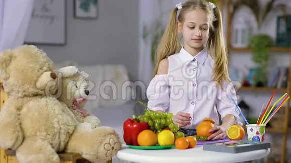 美丽的女孩用水果和蔬菜制作工艺品视频的预览图