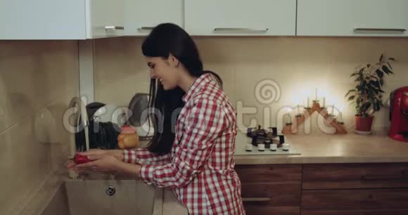 小女孩在厨房里洗豆科植物她在微笑4k视频的预览图