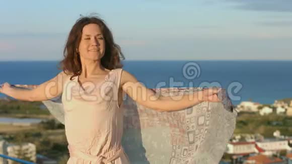 年轻迷人的女人带着围巾跳舞享受海滨度假胜地的假期视频的预览图