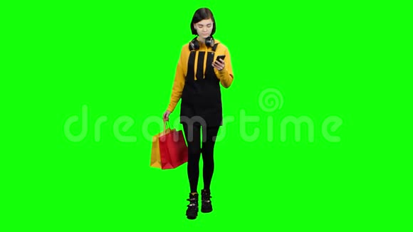 女孩来自一家商店手里拿着包裹和电话绿色屏幕视频的预览图