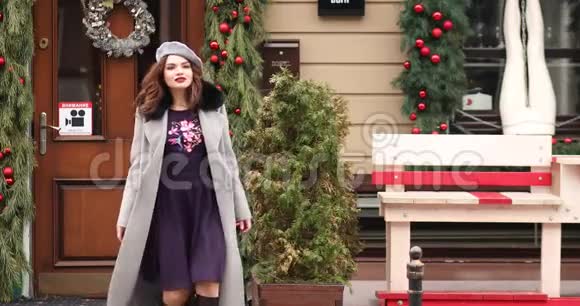 穿着灰色外套的漂亮女孩和贝雷帽走向圣诞商店视频的预览图