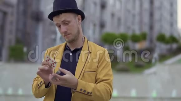 戴帽子穿黄夹克手拿扑克牌的错觉视频的预览图