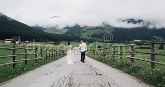 令人惊叹的复古道路迷人的山景和迷人的夫妇走下来慢动作视频的预览图