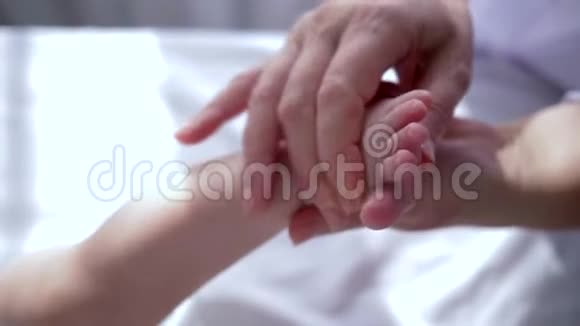按摩师用手按摩婴儿小脚特写视频的预览图