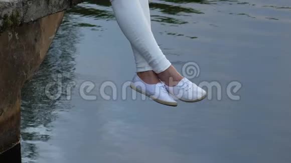 穿着白色鞋子在水里摆动的女性腿视频的预览图