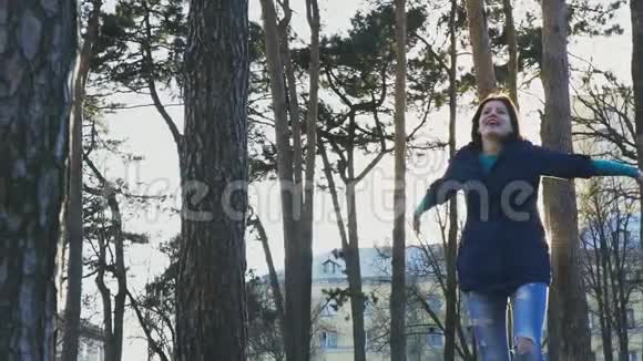 快乐的女人在夕阳的背景下在公园里快乐地跳跃幸福的概念慢动作120fps视频的预览图