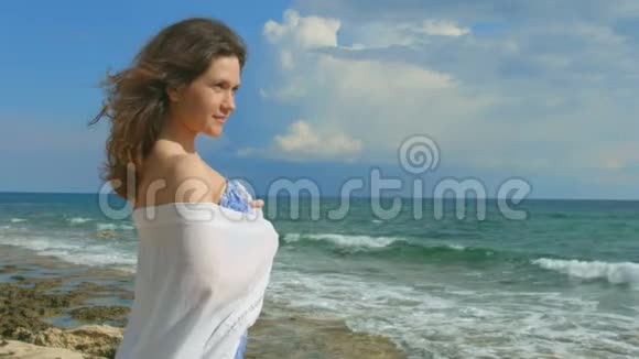 漂漂亮亮的神秘女人独自站在海边欣赏美丽的海景视频的预览图