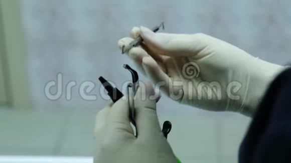 手套牙医准备在牙齿特写上安装支架系统的工具视频的预览图