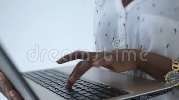 年轻可爱的非洲女商人在白色办公室的笔记本电脑上工作的迷人微笑的肖像视频的预览图