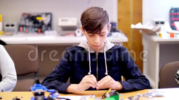 这个12岁的男孩从立方体盘子电路电线中扮演设计师小发明家创造机器人视频的预览图