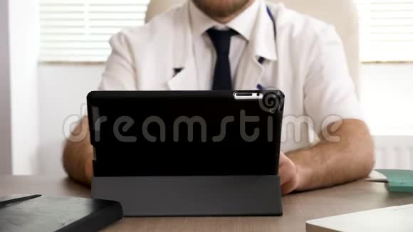 他桌上的医生正在研究一台数码平板电脑视频的预览图
