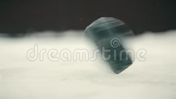 冰场上黑色冰球快速近距离旋转视频的预览图