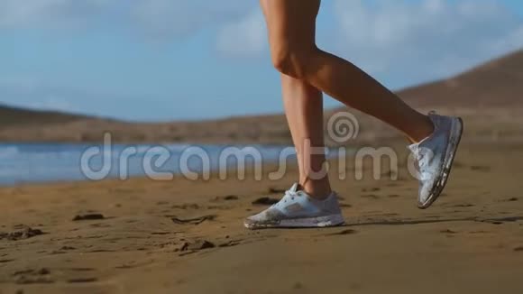 特写镜头的一位穿白色运动鞋的女士在沙滩上行走美丽的白沙慢动作稳定视频的预览图