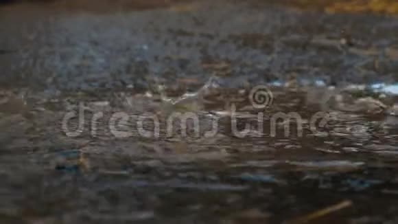 雨滴滴在水坑里喷着特写镜头大雨慢动作视频的预览图
