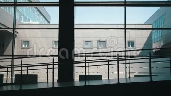 母亲和小女儿的剪影在大窗户的背景下走下机场的大门视频的预览图