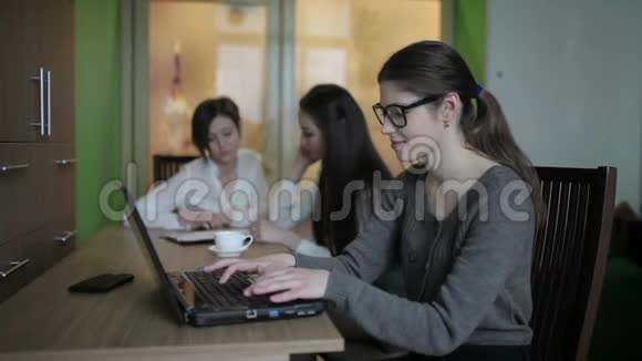 女孩把眼镜放在笔记本电脑键盘上视频的预览图