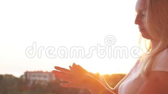 女人在阳光下的双手展开奶油慢动作视频的预览图