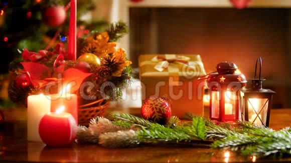 用蜡烛和礼物装饰精美的圣诞桌贴在发光的圣诞树上并燃烧视频的预览图