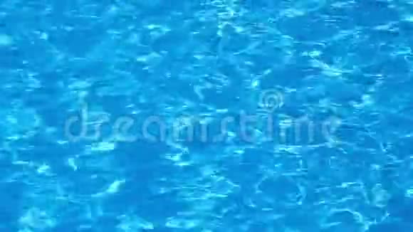 游泳池蓝色和明亮的波纹水面在阳光反射下缓慢运动全高清视频的预览图