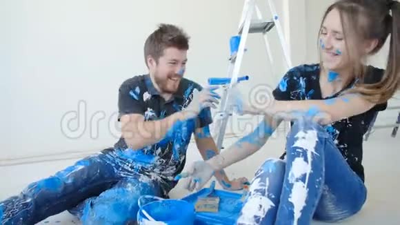 年轻幸福的一对夫妇在装修房子时玩得很开心视频的预览图