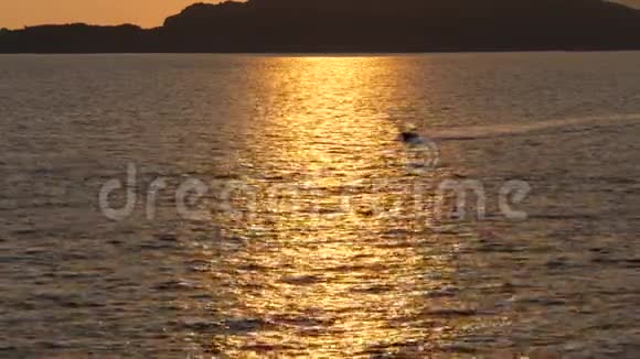 在阳光明媚的道路上小摩托艇在日落的海面上行驶视频的预览图