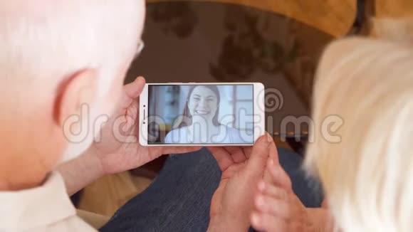 在家的老夫妇通过信使应用程序与女儿在国外进行视频聊天视频的预览图