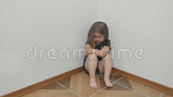 眼睛附近有瘀伤的心烦意乱的小女孩正在地板上的角落里哭泣视频的预览图