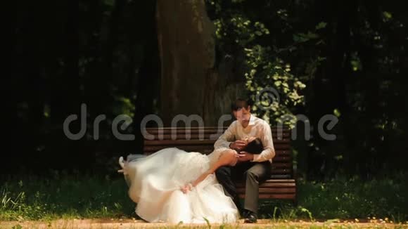 浪漫的气氛漂亮的一对新婚夫妇正在温柔地接吻英俊的新郎轻轻地抚摸着她的脸颊视频的预览图