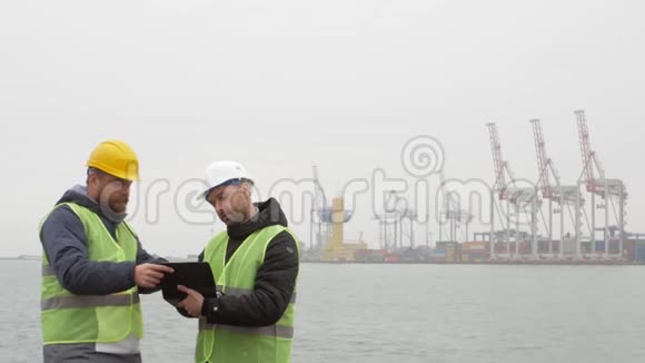 港口工人戴着头盔在看文件海运视频的预览图