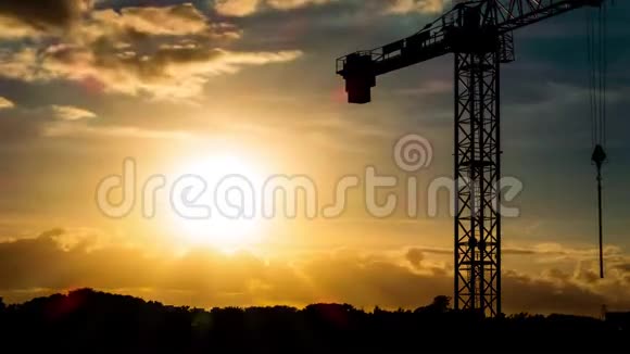 美丽的日落阳光照射在城市上空鹤形轮廓视频的预览图