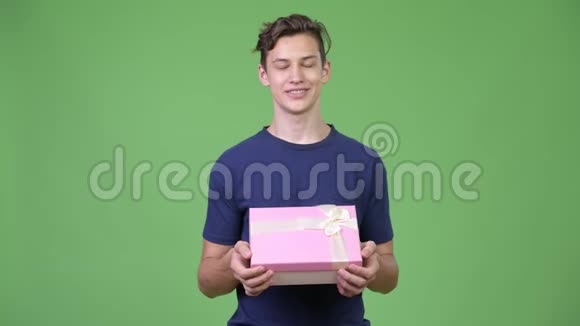 年轻英俊的少年想着礼物盒视频的预览图