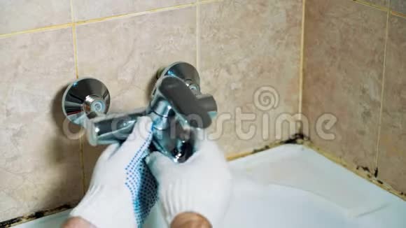 水管工的特写戴手套的手在浴室里安装水龙头视频的预览图