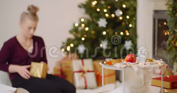 妇女在家用壁炉包圣诞礼物视频的预览图