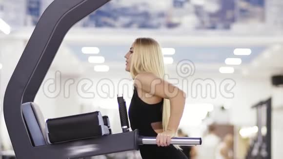漂亮的金发女孩在健身房做仰卧起坐健康的生活方式耐力和动力视频的预览图