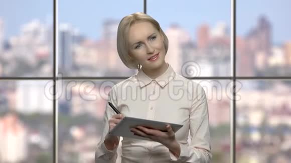 微笑的办公室女人在电脑平板电脑上工作视频的预览图