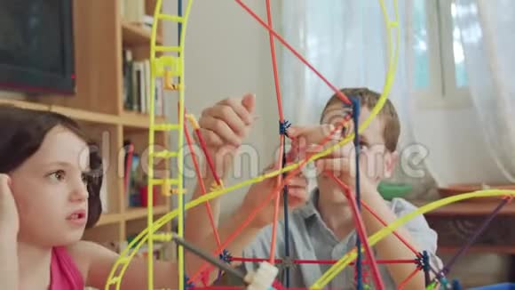 男孩和女孩在家里用玩具建造一座塔视频的预览图