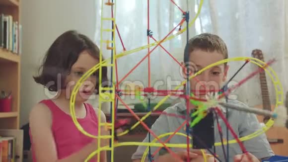 男孩和女孩在家里用玩具建造一座塔视频的预览图