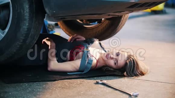 机械师女孩躺在车下伸手抓住扳手火状薄片视频的预览图